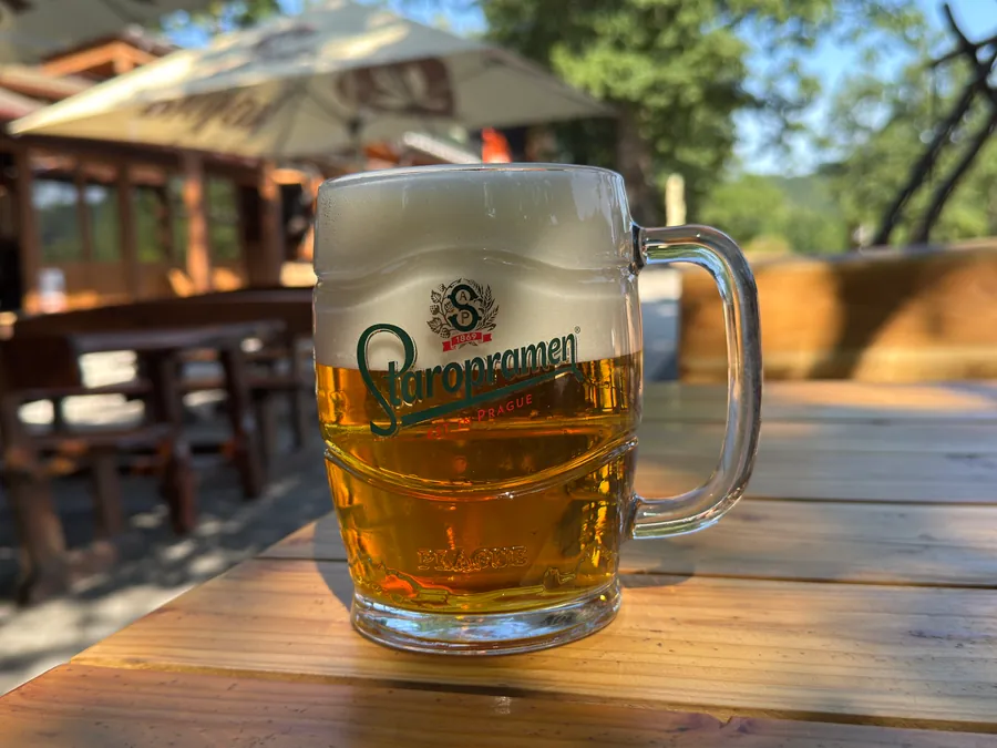 Bar u Blaškov na Počúvadle — čapované pivo Staropramen na stole letnej terasy